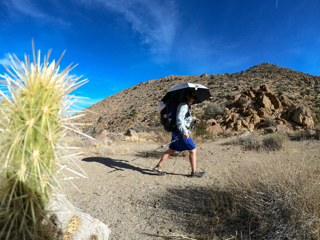 Hiker using a Hiking Umbrella in the desert. Silver Shadow Sun Umbrella protects against harmful rays at UPF 50+